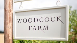 A sign that reads "WOODCOCK FARM". - Cotswolds Barn Apartment - luxury self catering near Bath & Bristo (Bristol)