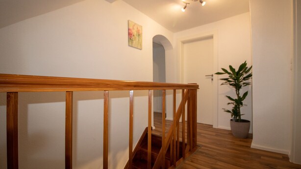Eine Treppe mit hölzernen Geländern, die zu einer Tür führt.
