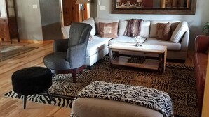 A living room with a sofa, armchair, ottoman, and a patterned rug. - The Ultimate Outdoor Adventure with Indoor Comfort (Darby)