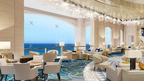 A spacious hotel lobby with a view of the ocean, elegant chandeliers, and modern furniture. - Fairmont Marina Residences Abu Dhabi (Abu Dhabi)