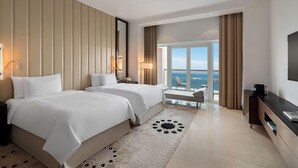 A hotel room with two beds, a large window with a view, a flat-screen TV, and a desk. - Fairmont Marina Residences Abu Dhabi (Abu Dhabi)