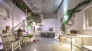 Un espace intérieur accueillant avec un coin salon central, une petite table et un jacuzzi.