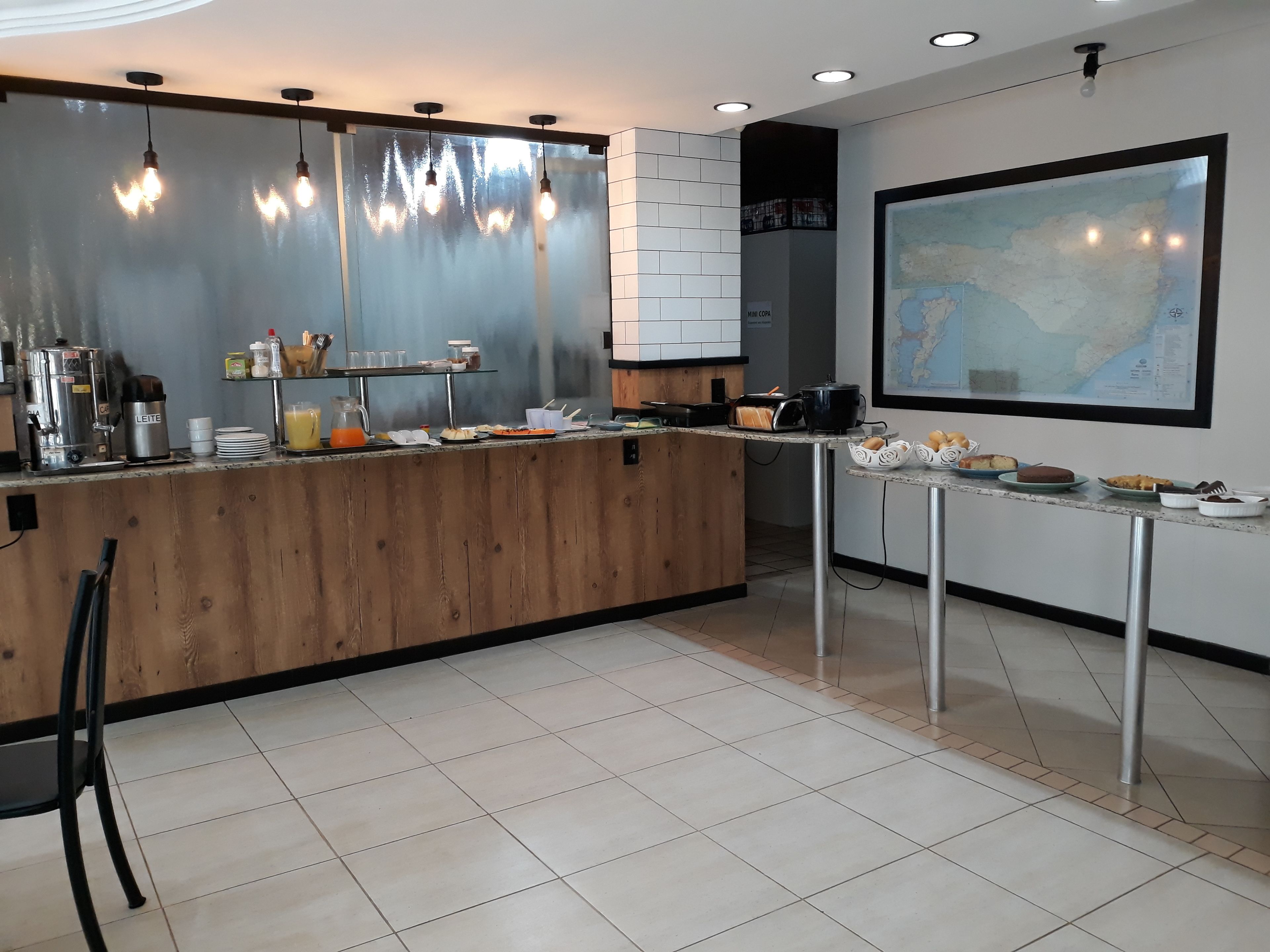 Una cocina moderna con una isla de madera, electrodomésticos de acero inoxidable y un mapa grande en la pared.