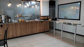 Una cocina moderna con una isla de madera, electrodomésticos de acero inoxidable y un mapa grande en la pared.