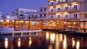 A waterfront restaurant with outdoor seating and a sign reading "KALIDON THE FLOATING RESTAURANT". - Aristea Hotel (Agios Nikolaos)