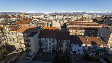 A cityscape with buildings, some with balconies, and a mountainous backdrop.