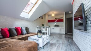 A modern loft-style apartment with a loft bed, a dining area, and a kitchen. - Apartamenty hoteLOVE pod Debami (Karpacz)