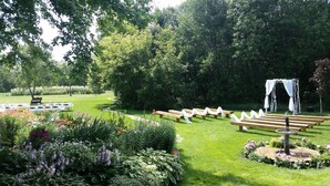 A garden setting with a seating area, a fountain, and a white arch structure. - Garden Lodging In A Peaceful Country Farm Setting ~ "Longspur" House  (Carrington)