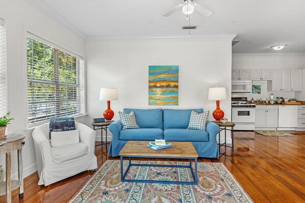 A living room with a blue sofa, a coffee table, and a painting on the wall.