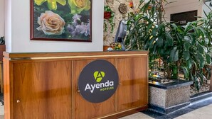 A reception desk with a wooden finish and a logo for 'Ayenda Hoteles'. - Hotel Bogota Alpes Polo Club (Bogotá)