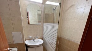 A bathroom with a glass shower enclosure, a sink, and a toilet. - Hotel Beatris (Nessebar)