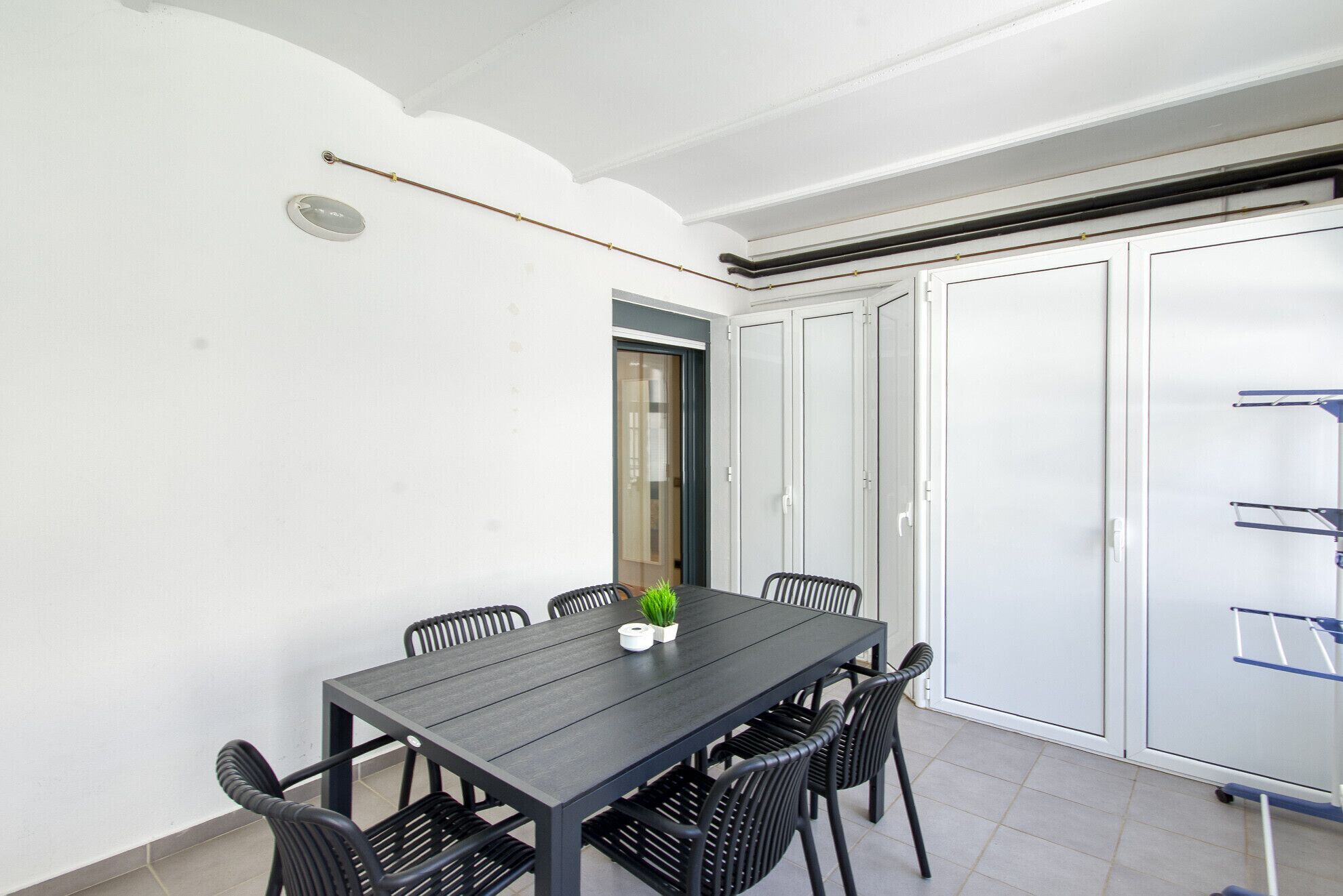 A dining area with a table and chairs, a potted plant, and a door leading to a closet.