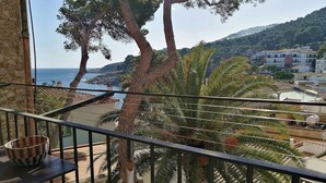 Un balcon avec vue sur la mer, les palmiers et les bâtiments.