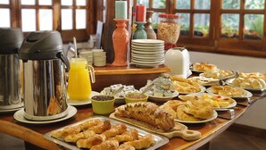 A breakfast buffet with pastries, bread, and beverages. - Posada del Sauce (Villa General Belgrano)