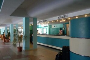 A reception area with a reception desk, a sign for 'CHANGE,' and a potted plant. - Zefir Hotel (Nessebar)