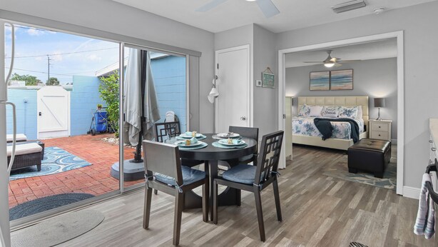 A modern interior with a dining area, a bedroom, and a view of the backyard.