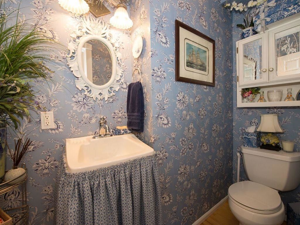 A bathroom with a sink, mirror, and toilet.