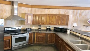 A kitchen with wooden cabinets, a stainless steel stove, a microwave, and a coffee maker.