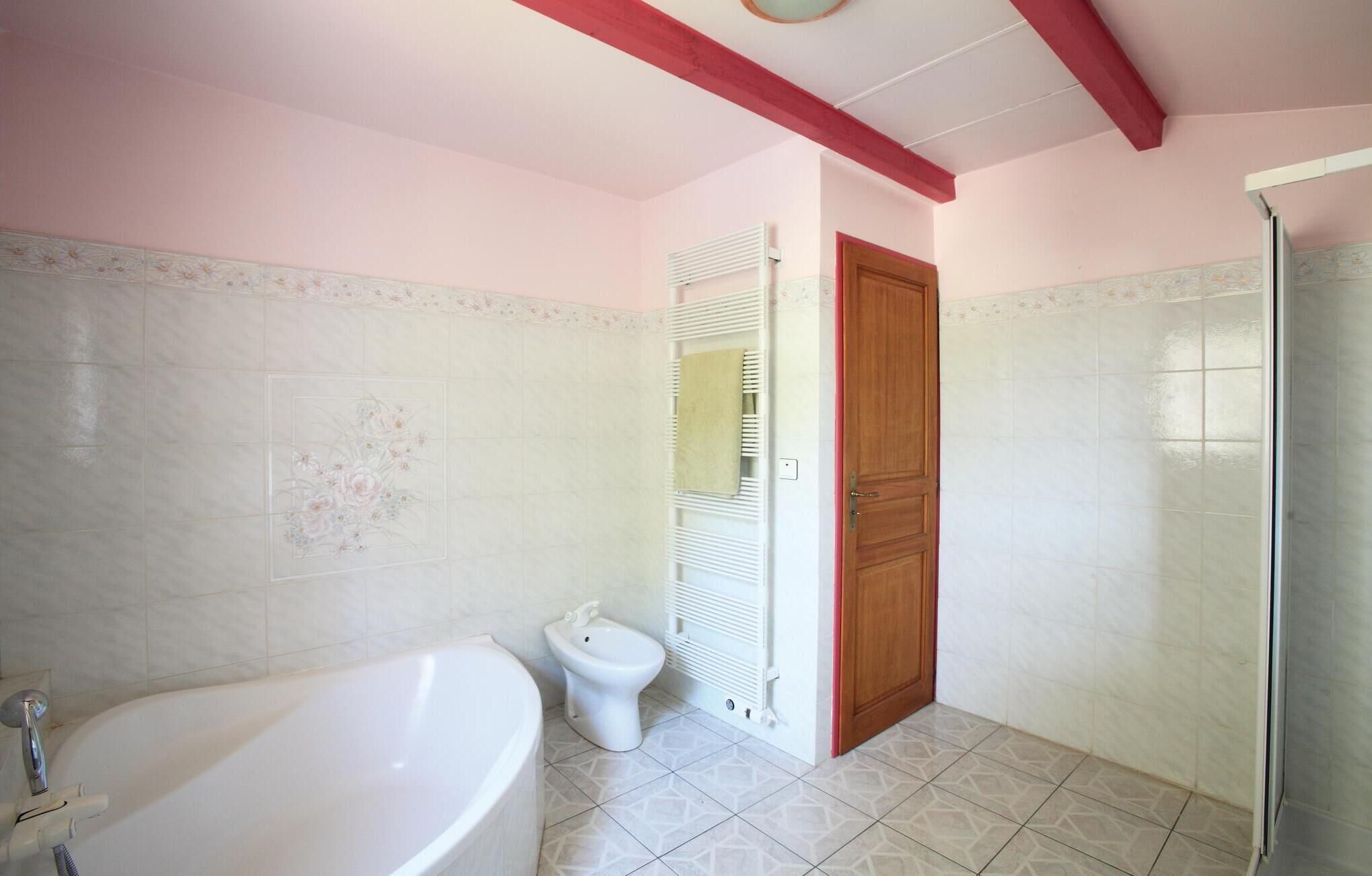 A bathroom with a bathtub, toilet, and shower.