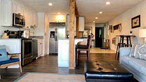 A spacious living area with a sofa, a dining table, and a kitchen with modern appliances. - The Overlook at Lake Hamilton - Contemporary Design, Private Deck & Boat Slip! (Hot Springs)