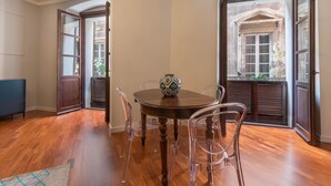 A dining area with a round table, clear chairs, and a decorative vase. - Suite 101 - Cagliari (Cagliari)