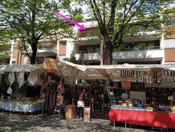 Un marché en plein air où divers stands proposent à la vente des articles tels que des sacs et des accessoires.