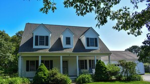 A two-story house with a front porch, a covered entryway, and a well-maintained lawn.