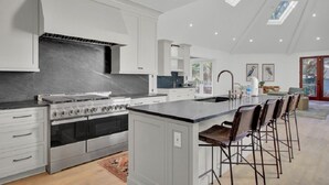 Una cocina moderna con una isla central, electrodomésticos de acero inoxidable y un tragaluz.