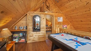 A cozy wooden cabin with a loft bedroom, a dining table, and a game table. - Best Price!!! Cabin with Mountain Views, Hot Tub, Sleeps 6, 10 Min to Parkway! (Sevierville)