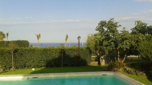A swimming pool with a view of the ocean and palm trees. - Luxury Villa with Large Pool, Vineyard, Views of the Sea, Taormina  and Mt.Etna (Acireale)