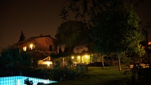 A house with a swimming pool, surrounded by trees and a well-lit patio area. - Luxury Villa with Large Pool, Vineyard, Views of the Sea, Taormina  and Mt.Etna (Acireale)