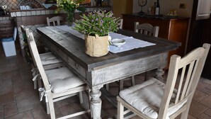 A rustic dining table with a woven plant pot and a bowl, surrounded by striped cushioned chairs. - Luxury Villa with Large Pool, Vineyard, Views of the Sea, Taormina  and Mt.Etna (Acireale)