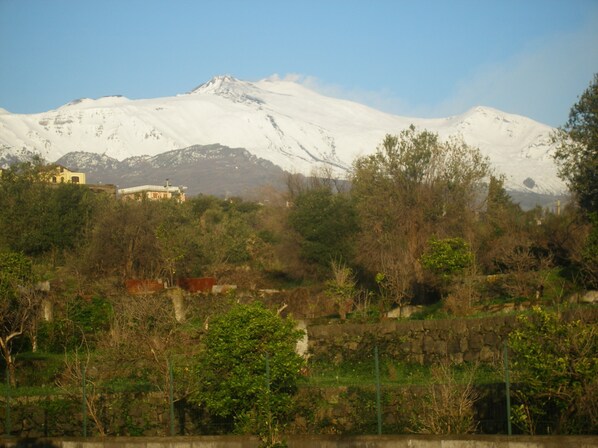 A snow-capped mountain with a building in the foreground.