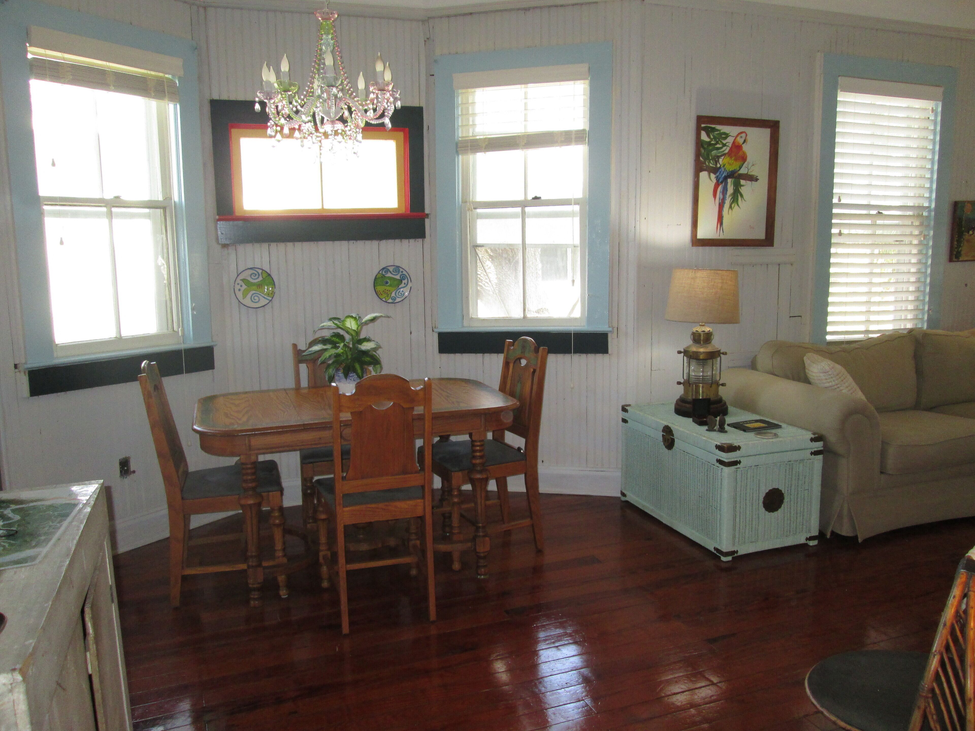 Uma área de refeições com uma mesa e cadeiras de madeira, um candelabro e um rádio antigo.