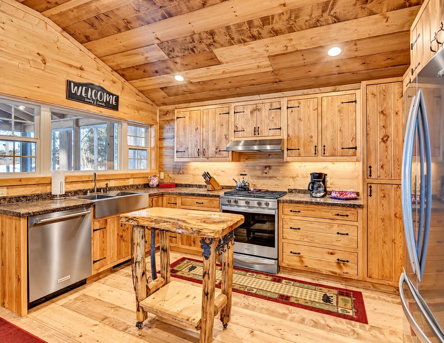 A wooden interior with a kitchen featuring cabinets, a stove, and a refrigerator.