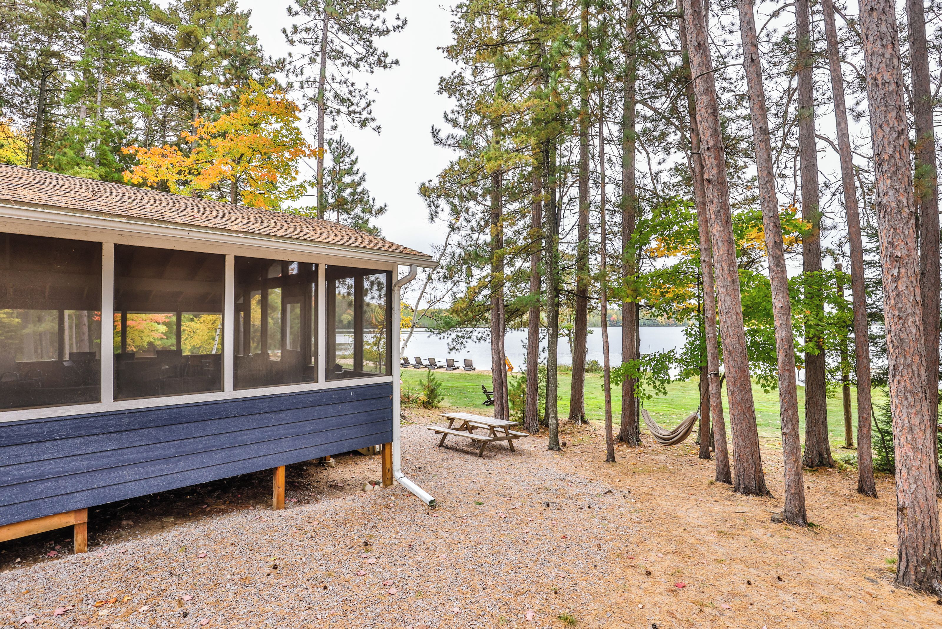 A cabin with a covered porch, a picnic table, and a hammock.