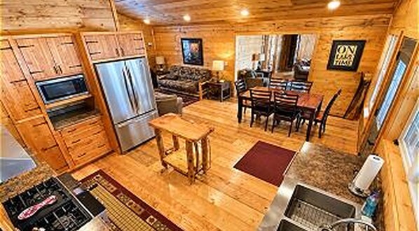 A compact kitchen with a refrigerator, stove, and dining area with chairs and a table.
