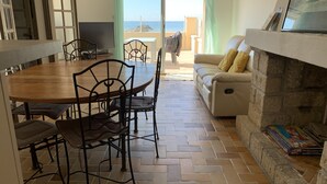 Un comedor con una mesa y sillas de madera, un sofá y una chimenea.
