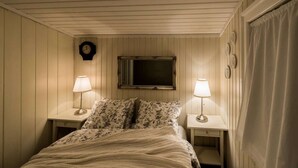 Una camera da letto con un letto, due comodini, due lampade, una sveglia e una finestra con tende.