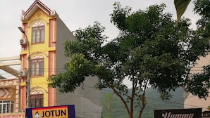 Edifici amb façana groga i un rètol per als negocis 'JOTUN' i 'YUMMY'.