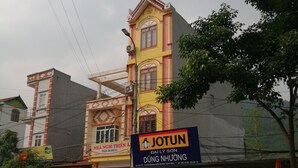 Un edifici de diversos pisos amb un distintiu cartell de JOTUN, que indica un establiment comercial.