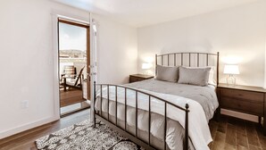 A bedroom with a bed, nightstands, and a patterned rug. - The Salida Opera House Loft (Salida)