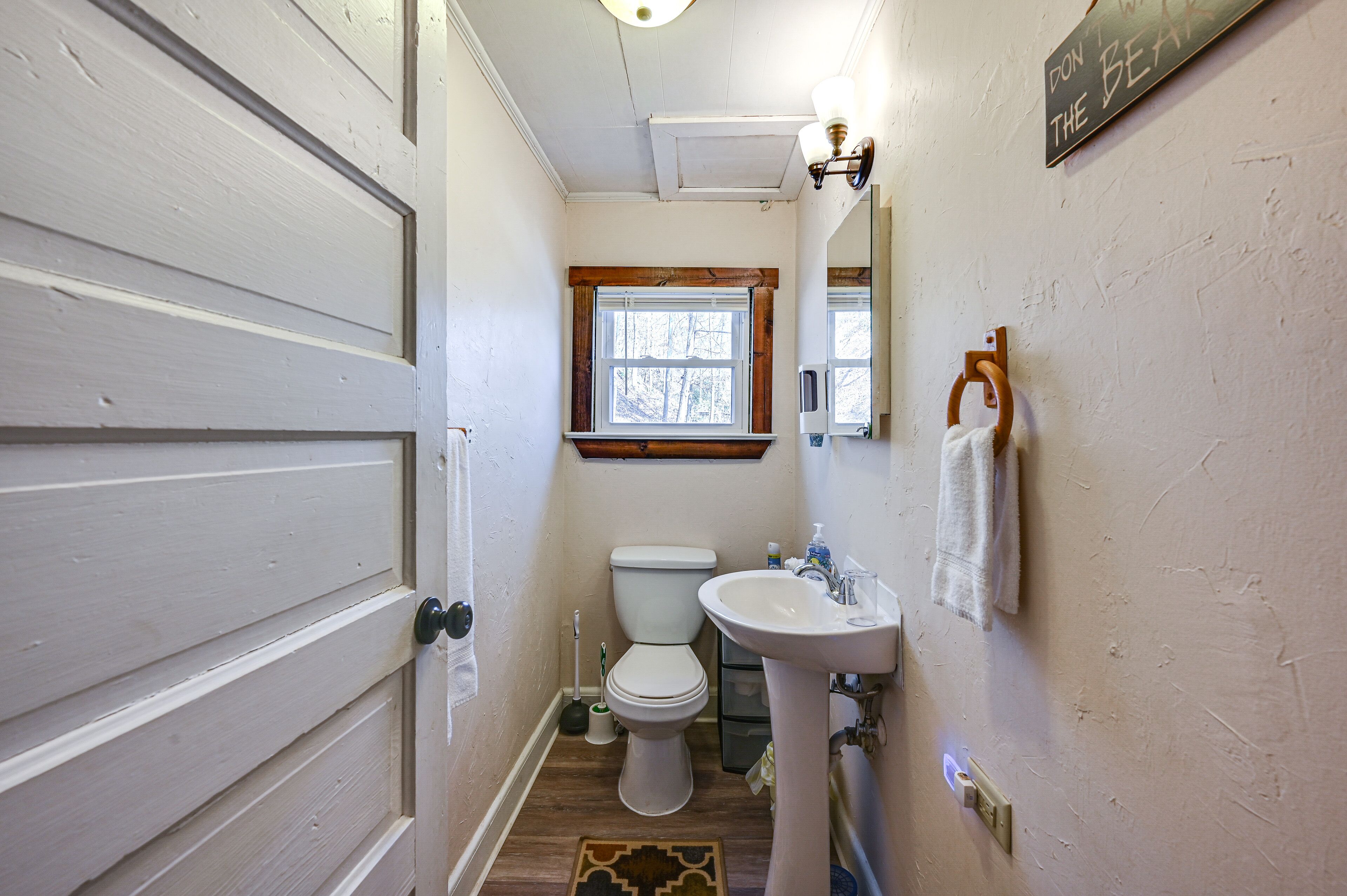 A compact bathroom with a toilet, sink, and window.