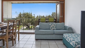 A balcony with a sofa, chairs, and a table.