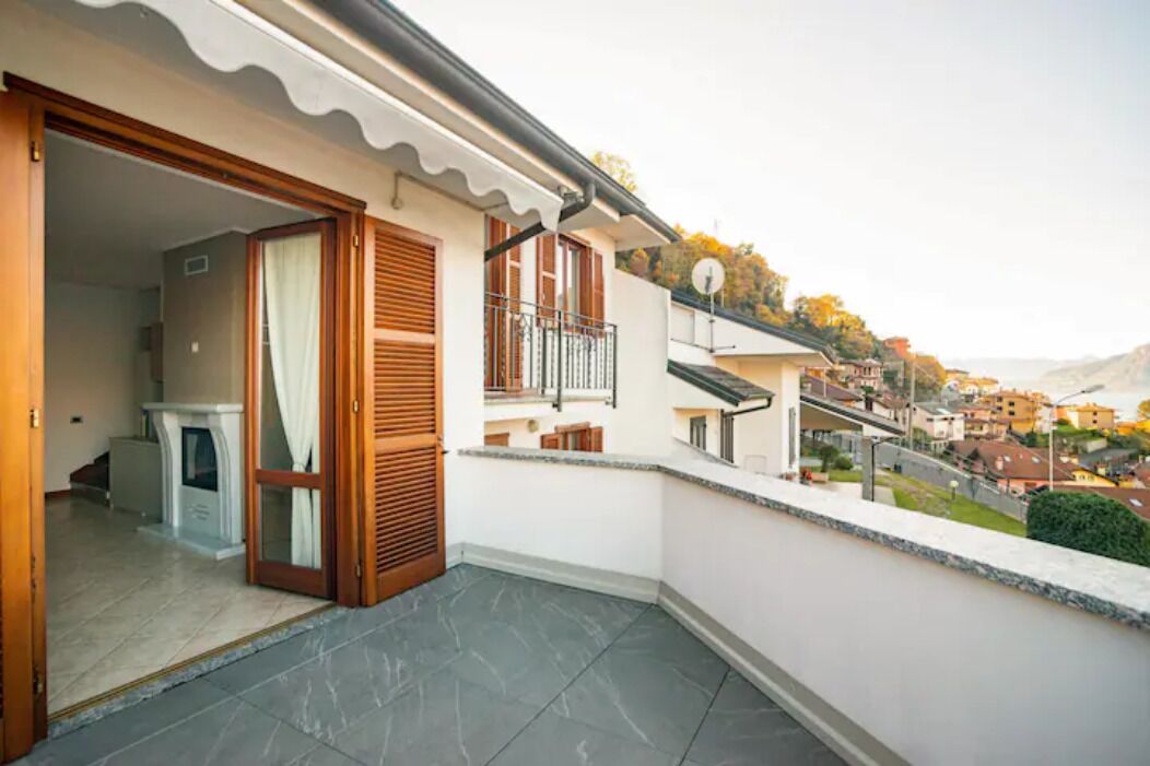A residential balcony with a view of a hillside town.