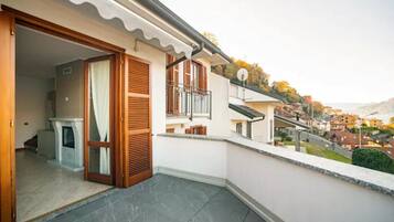A residential balcony with a view of a hillside town.