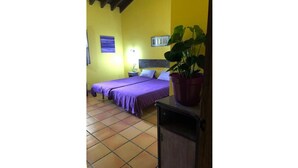 A room with two beds, a nightstand, a potted plant, and a tiled floor. - Holidays in Asturias (Asturias)