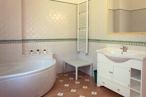 A bathroom with a bathtub, toilet, sink, and a mirror. - Comfortable independent holiday home with direct access to the beach of Ascea (Marina di Ascea)