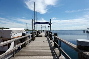 A wooden pier leading to a dock with boats and a sign reading "SCHIFFSTÜREN MACHE WISMAR".