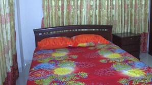 A bedroom with a bed, curtains, and a nightstand. - Furnished Flat In Block C Bashundhara RA (Dhaka)